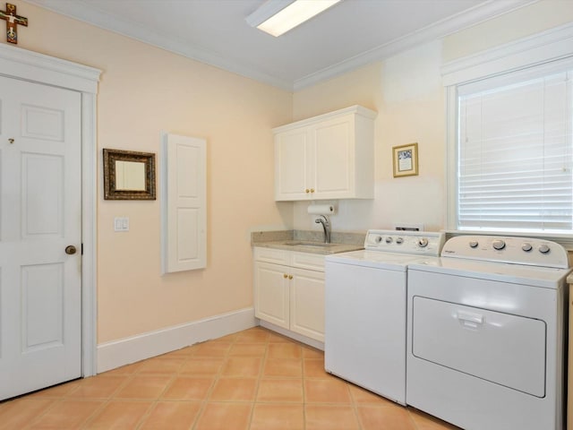 clothes washing area featuring cabinet space, baseboards, crown molding, washer and dryer, and a sink