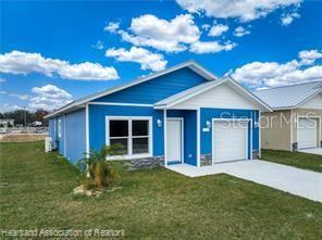 view of front of property featuring a garage and a front lawn