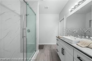 bathroom featuring vanity, a shower with door, and wood-type flooring