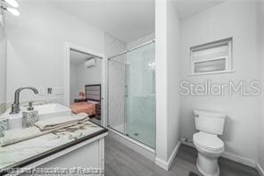 bathroom featuring vanity, wood-type flooring, toilet, and walk in shower