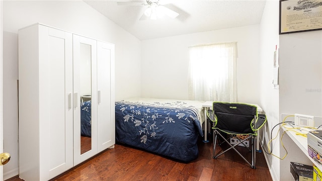 bedroom featuring lofted ceiling, dark hardwood / wood-style flooring, and ceiling fan