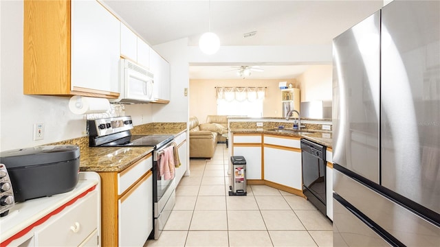 kitchen featuring stainless steel appliances, white cabinetry, sink, and decorative light fixtures