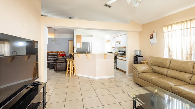 tiled living room with ceiling fan and lofted ceiling