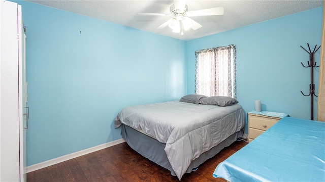 bedroom featuring ceiling fan, a textured ceiling, and dark hardwood / wood-style flooring