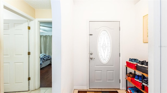 entrance foyer featuring light tile patterned floors and a textured ceiling