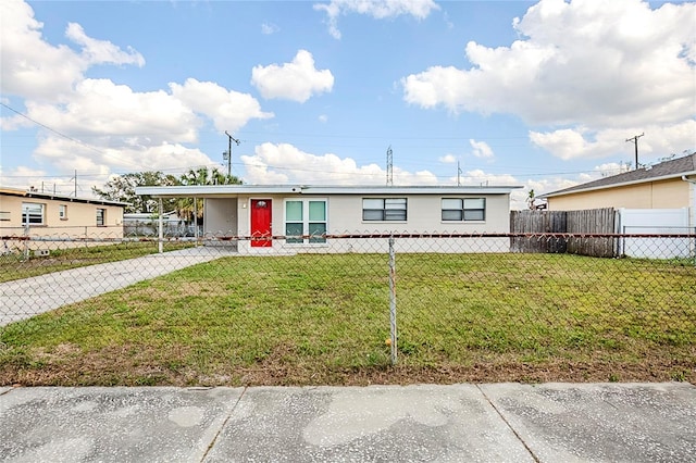 manufactured / mobile home with a fenced front yard, an attached carport, concrete driveway, and a front lawn