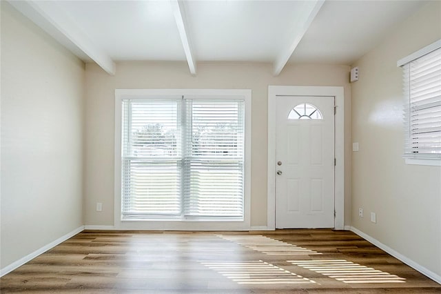 foyer with a healthy amount of sunlight, beamed ceiling, and wood finished floors