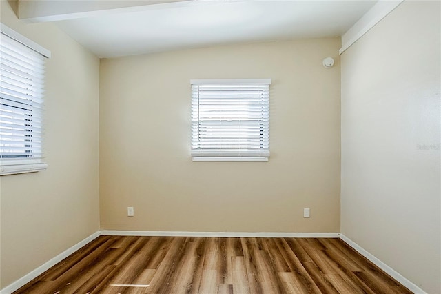 unfurnished room with baseboards and wood finished floors