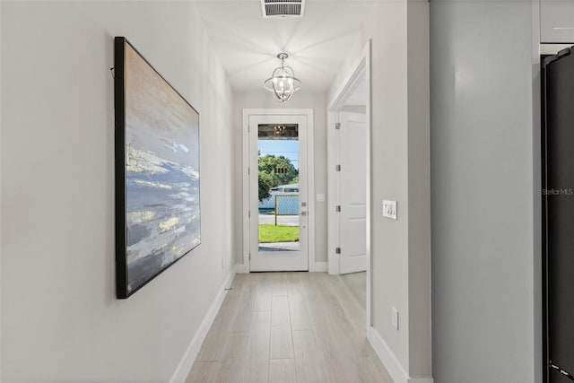 entryway with a chandelier and light wood-type flooring