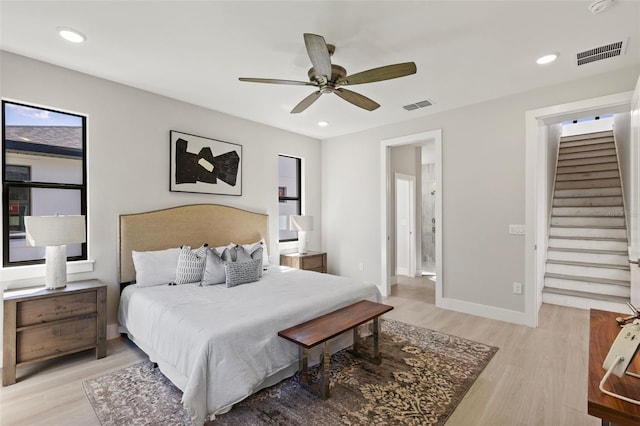 bedroom featuring ceiling fan, connected bathroom, and light hardwood / wood-style floors