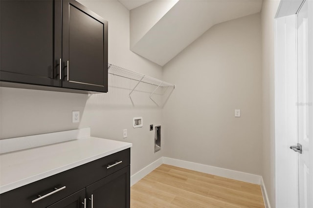 washroom with cabinets, electric dryer hookup, hookup for a washing machine, and light wood-type flooring