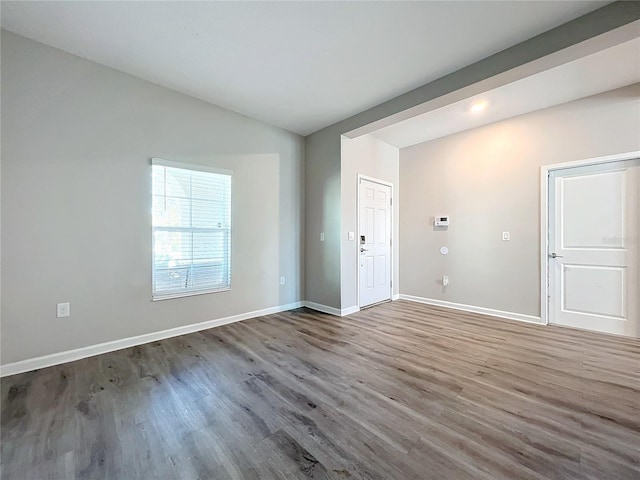 unfurnished room with wood-type flooring and vaulted ceiling