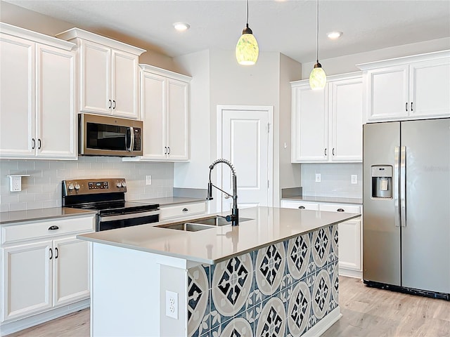 kitchen with white cabinetry, hanging light fixtures, sink, and appliances with stainless steel finishes