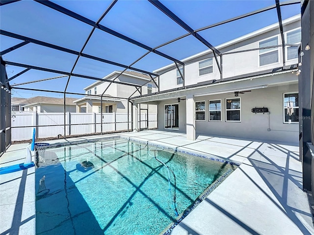 view of pool with a patio, ceiling fan, and glass enclosure