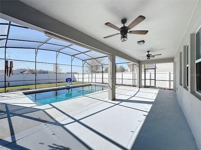 view of swimming pool featuring a patio area, ceiling fan, and glass enclosure