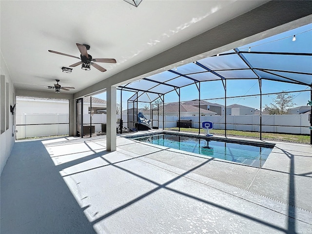 view of swimming pool featuring a patio, ceiling fan, and glass enclosure