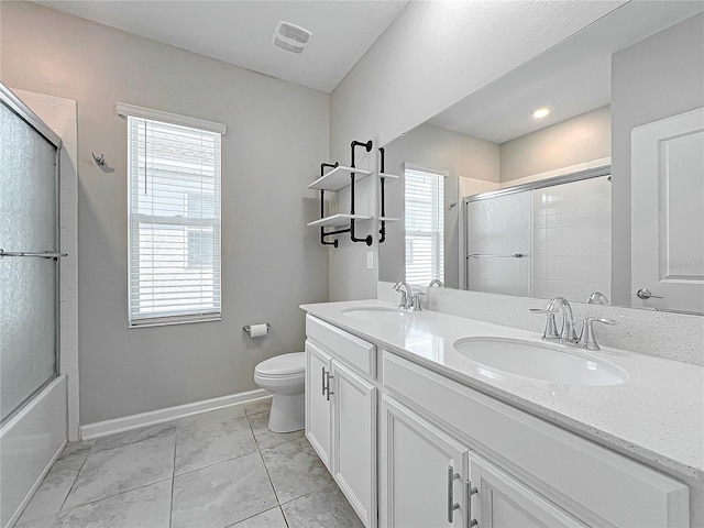 full bathroom featuring bath / shower combo with glass door, a healthy amount of sunlight, toilet, and vanity