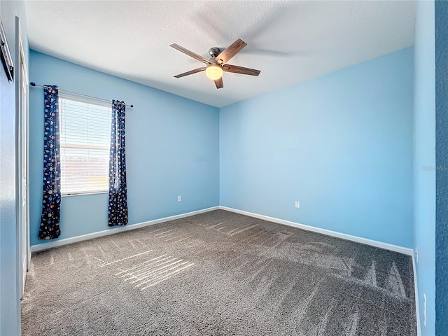 spare room featuring dark carpet, a textured ceiling, and ceiling fan