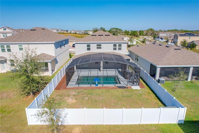 back of house with a fenced in pool, a lanai, a lawn, and central AC