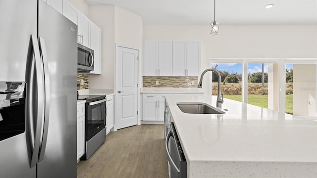 kitchen featuring sink, hanging light fixtures, white cabinets, and appliances with stainless steel finishes