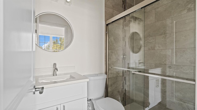 bathroom featuring an enclosed shower, vanity, and toilet