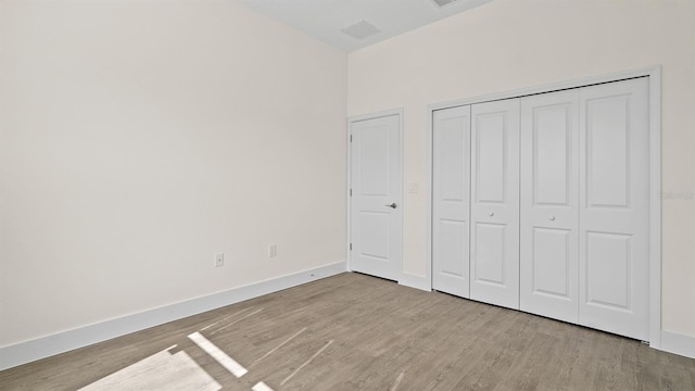 unfurnished bedroom featuring light hardwood / wood-style floors and a closet