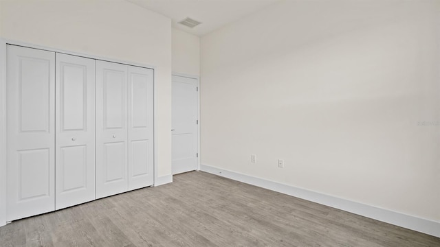 unfurnished bedroom featuring light hardwood / wood-style flooring and a closet