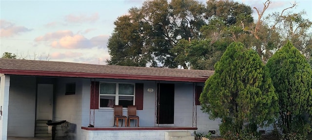 exterior entry at dusk featuring covered porch