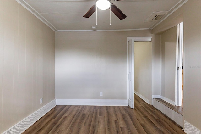 empty room with ceiling fan, wood finished floors, visible vents, and crown molding