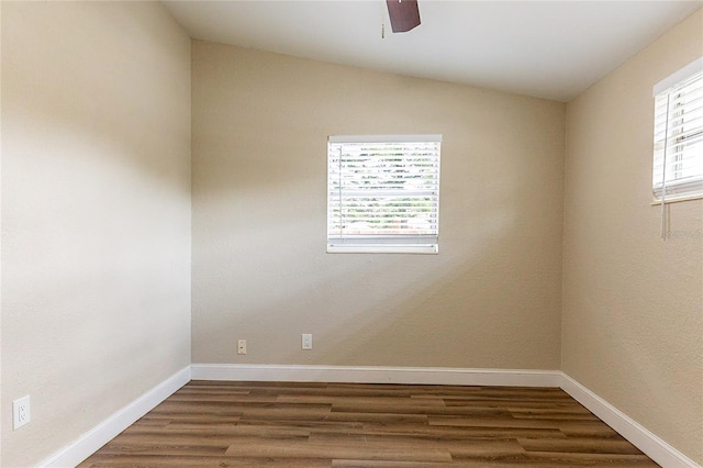 unfurnished room featuring lofted ceiling, plenty of natural light, baseboards, and wood finished floors