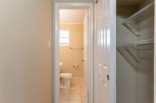 bathroom with tile patterned flooring, a closet, baseboards, and toilet