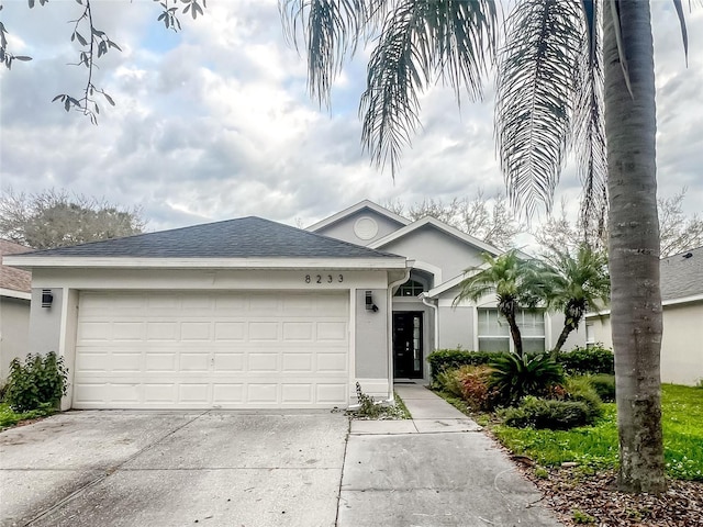 ranch-style home with concrete driveway, an attached garage, and stucco siding