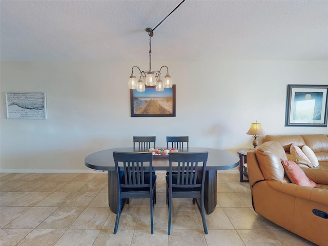 tiled dining area featuring a textured ceiling and an inviting chandelier