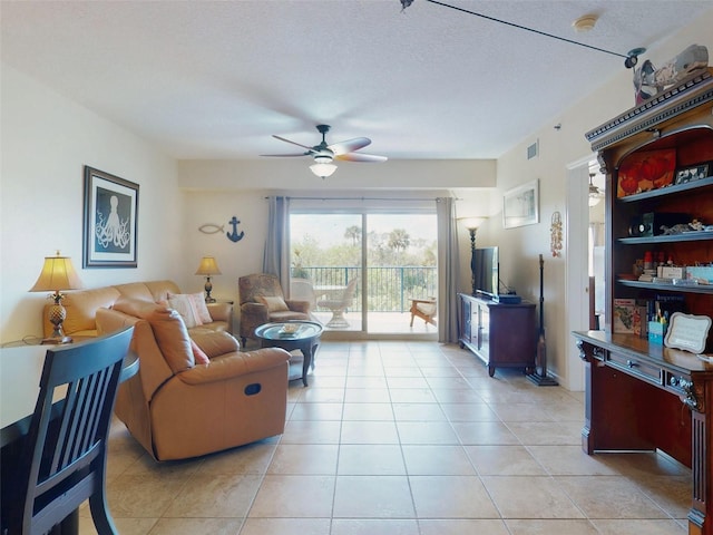 tiled living room with ceiling fan and a textured ceiling