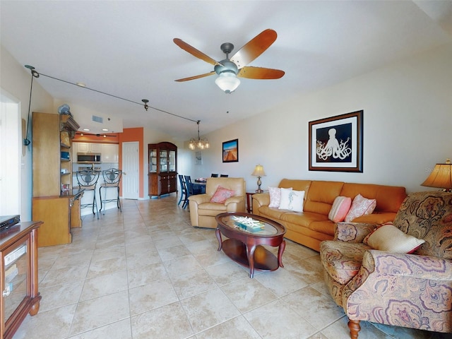 living room featuring light tile patterned flooring and ceiling fan with notable chandelier