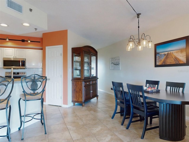 tiled dining room with an inviting chandelier and lofted ceiling