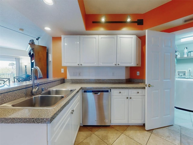 kitchen featuring sink, white cabinets, stainless steel dishwasher, light tile patterned floors, and kitchen peninsula