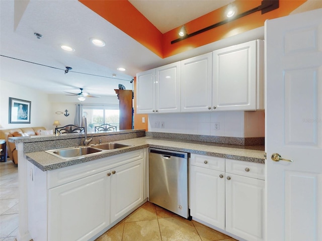 kitchen featuring sink, light tile patterned floors, white cabinets, stainless steel dishwasher, and kitchen peninsula