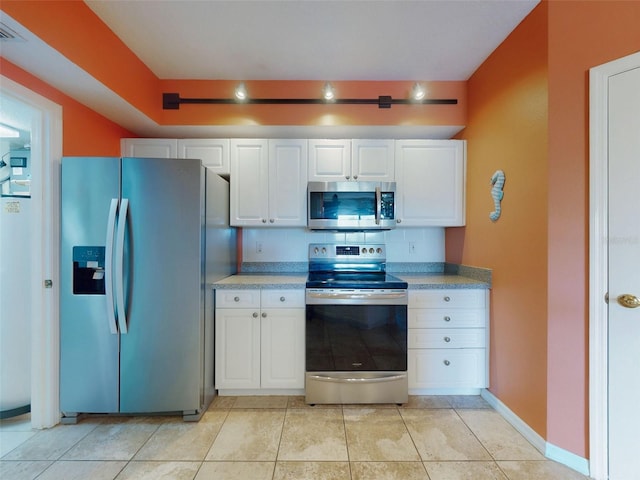 kitchen with white cabinetry, light tile patterned floors, and stainless steel appliances