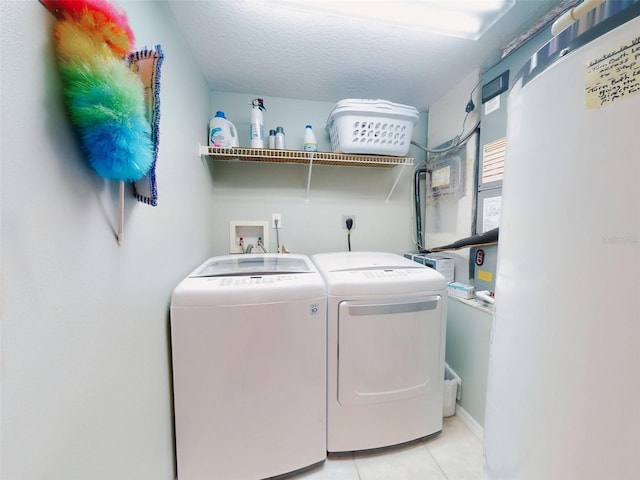 laundry room featuring separate washer and dryer, a textured ceiling, and light tile patterned floors