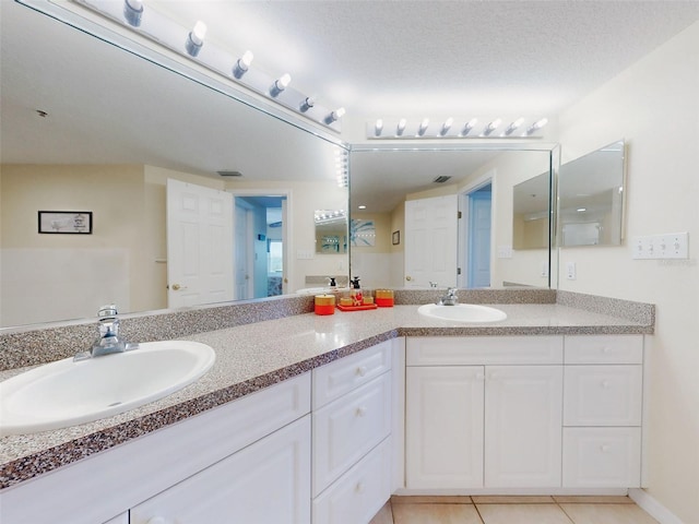 bathroom with vanity, tile patterned floors, and a textured ceiling