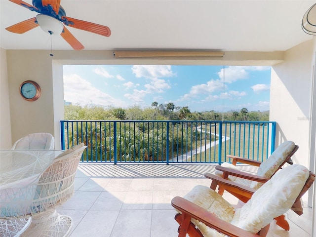 balcony with a water view, ceiling fan, and a patio