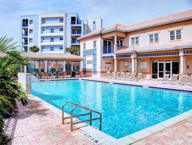 view of swimming pool featuring pool water feature and a patio