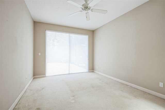 carpeted spare room featuring ceiling fan and a textured ceiling