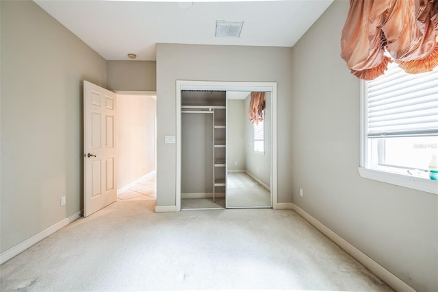 unfurnished bedroom with a closet and light carpet