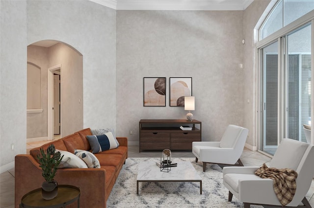 tiled living room featuring crown molding and a towering ceiling