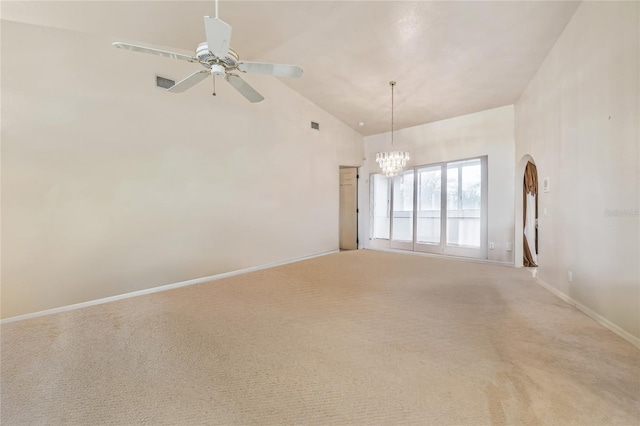 carpeted spare room with ceiling fan with notable chandelier and high vaulted ceiling