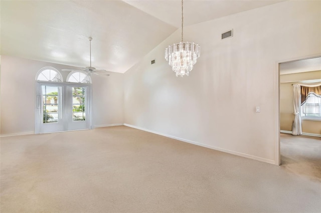 carpeted empty room with ceiling fan with notable chandelier and high vaulted ceiling