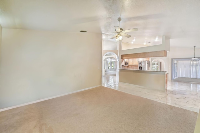 unfurnished living room featuring lofted ceiling, a wealth of natural light, and ceiling fan