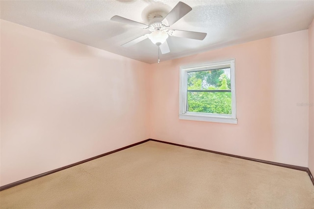 carpeted empty room with ceiling fan and a textured ceiling